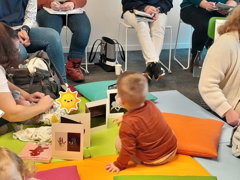 Bébé au milieu de livres sur un tapis