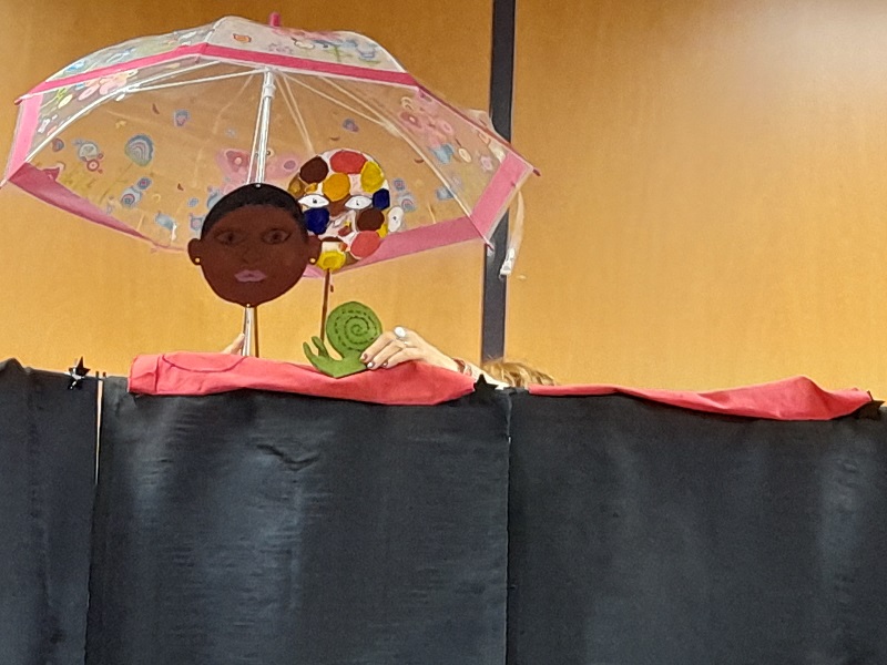 Marionnettes deux visages et un escargot sous un parapluie
