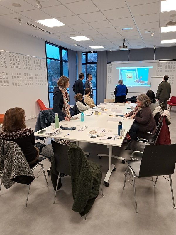 Stagiaires assis et debout autour d'une table 